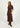 Woman wearing a patterned dress with brown boots on a white background